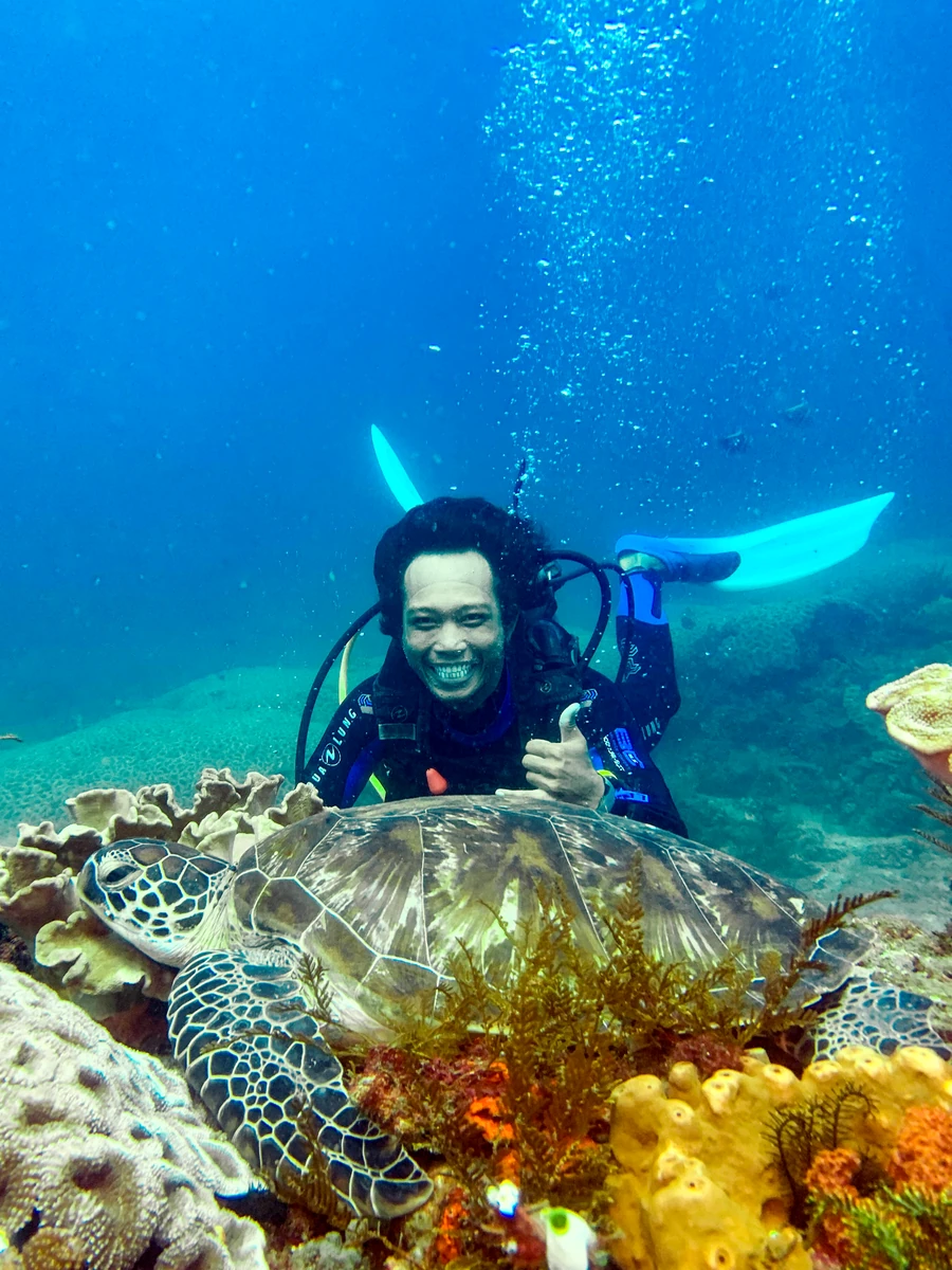 Lächelnder Taucher bei seiner Ausbildung am Riff auf Bali